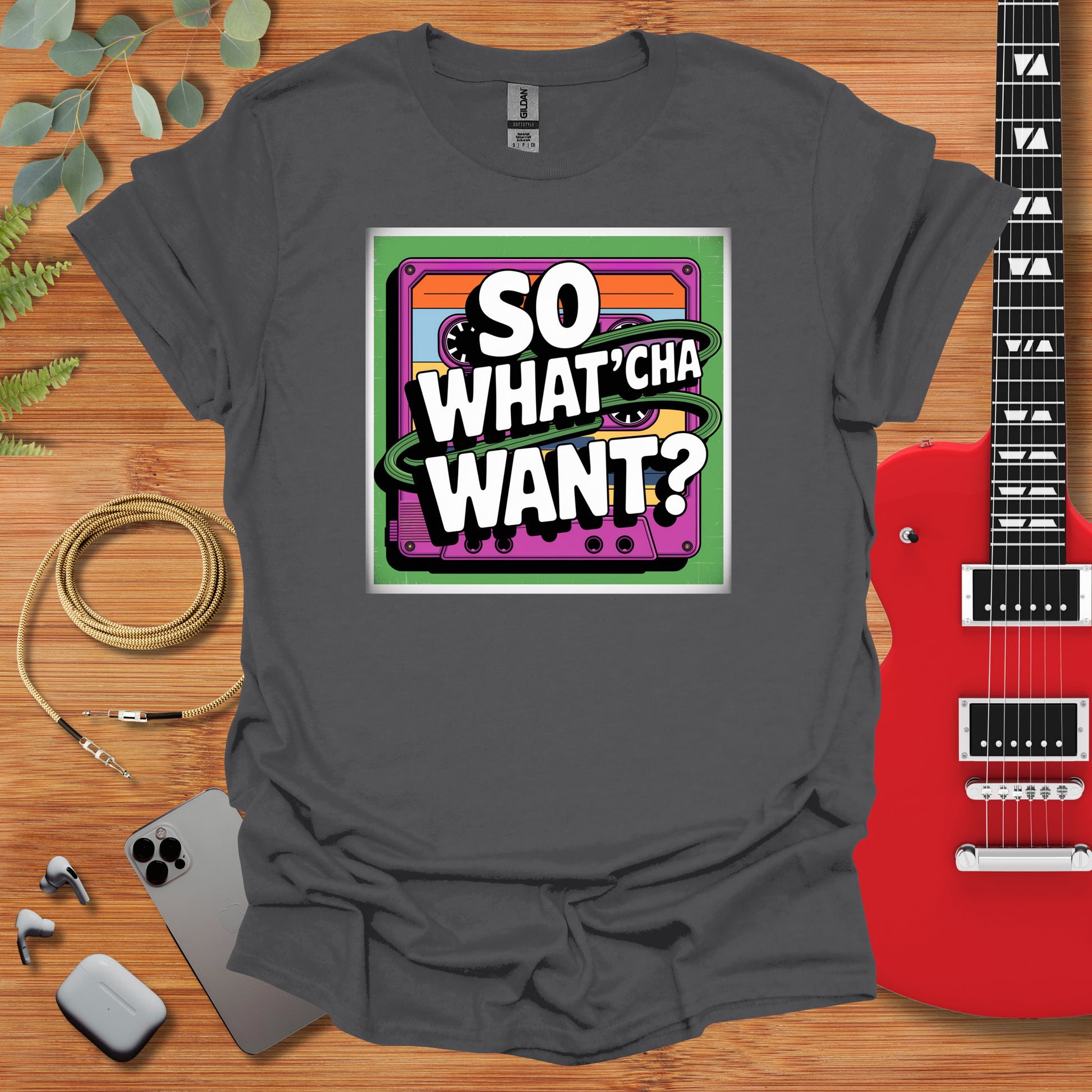 a t - shirt that says so whatcha want? next to a guitar