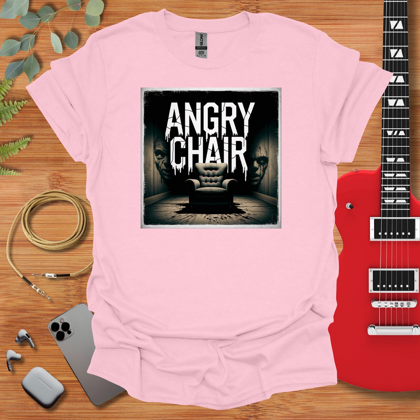 a pink shirt with an image of a chair and a guitar