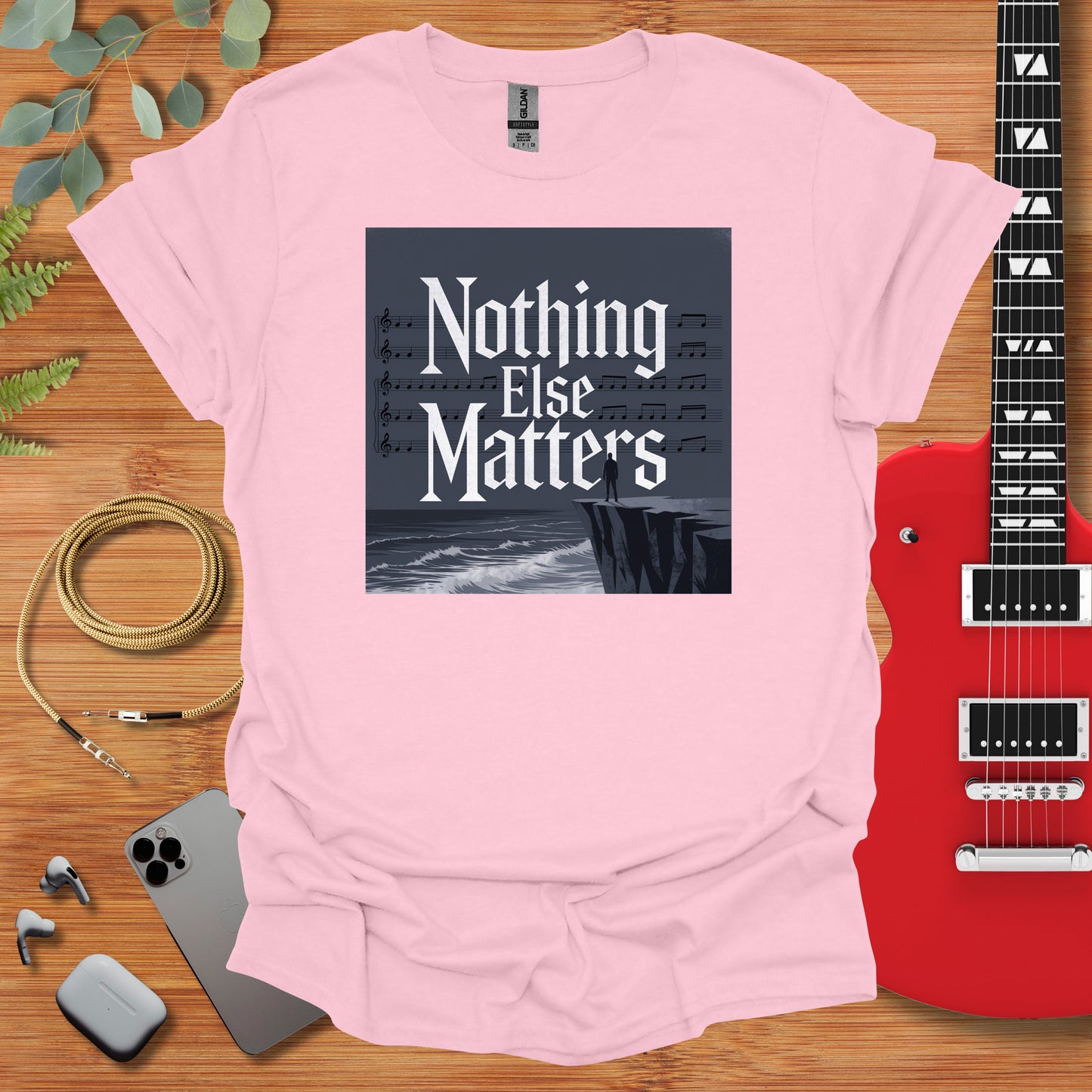 a t - shirt that says nothing else matters next to a guitar