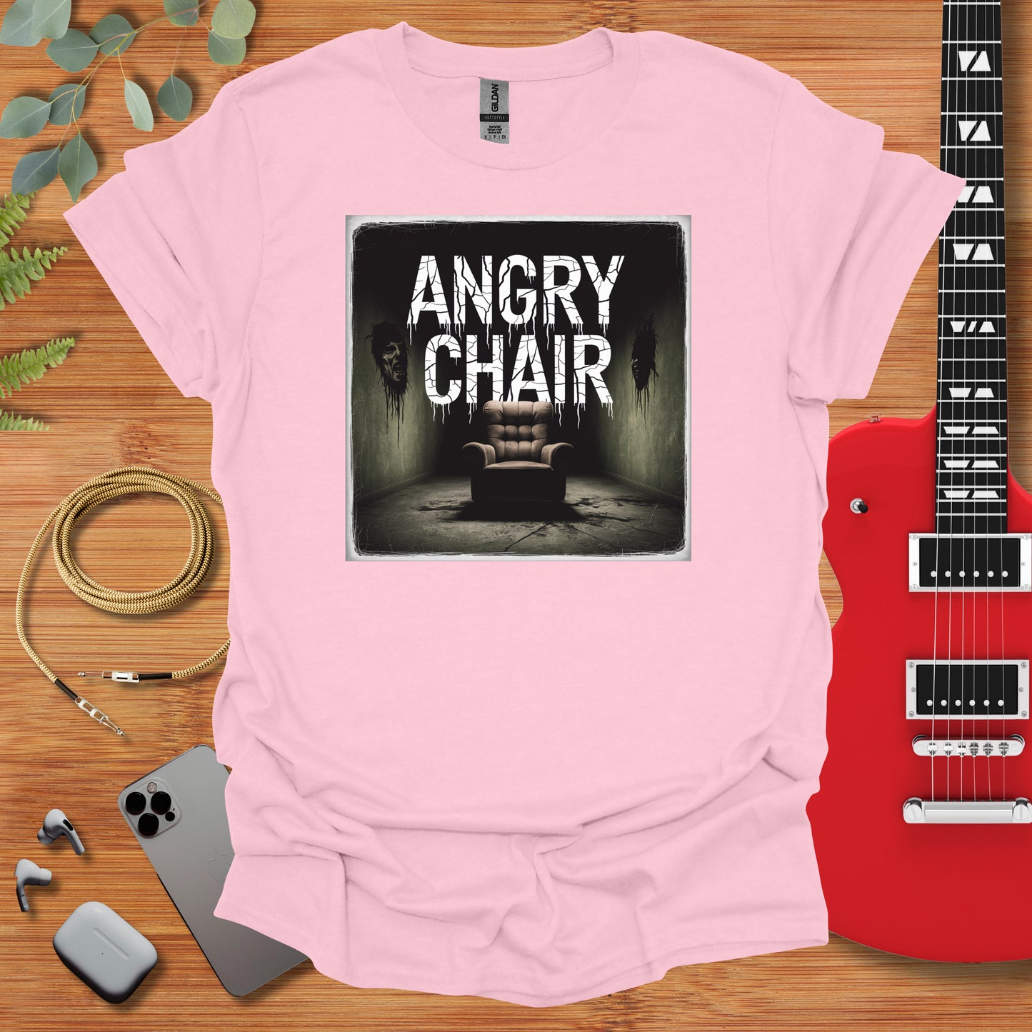 a pink shirt with an image of a chair and a guitar