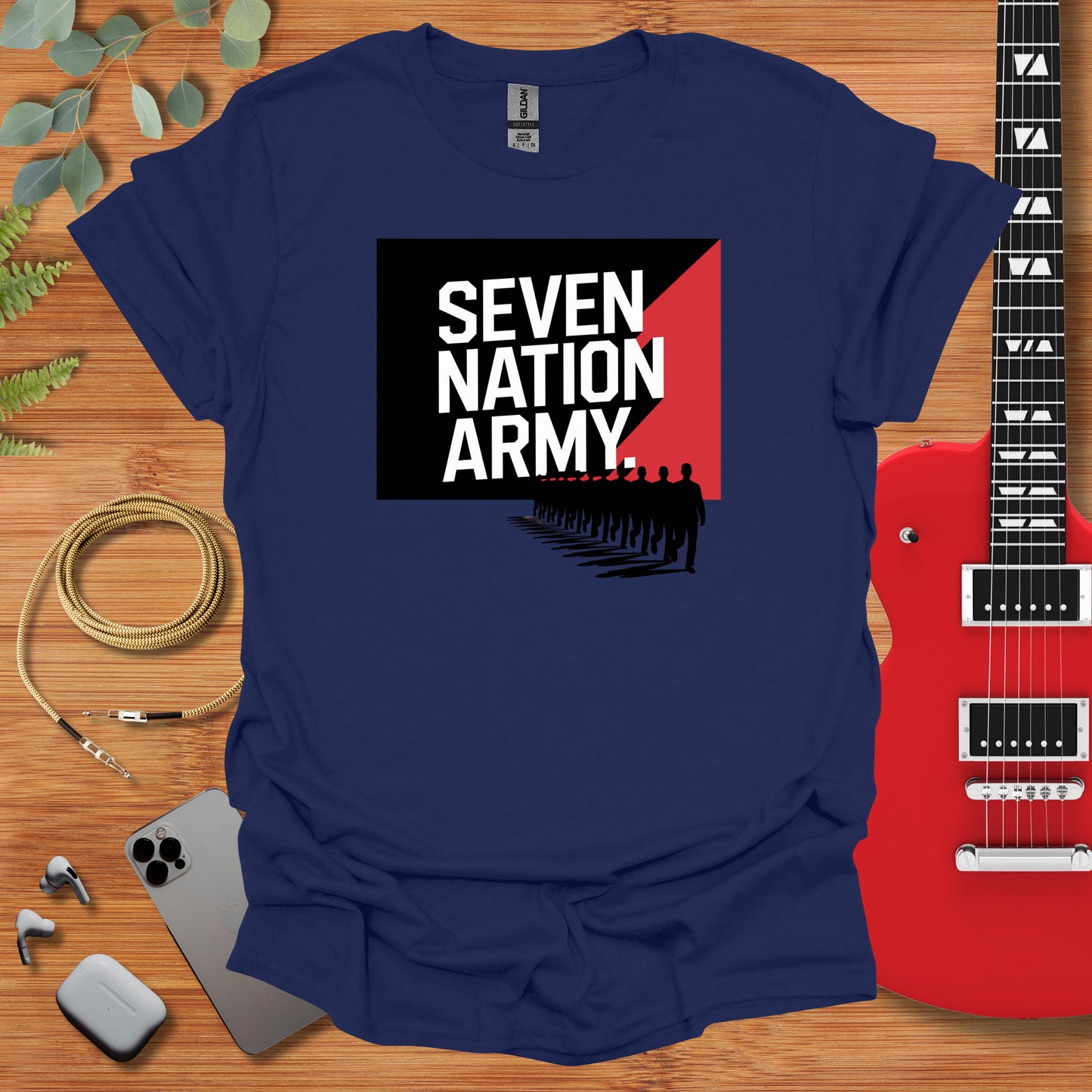 a shirt that says seven nation army next to a guitar