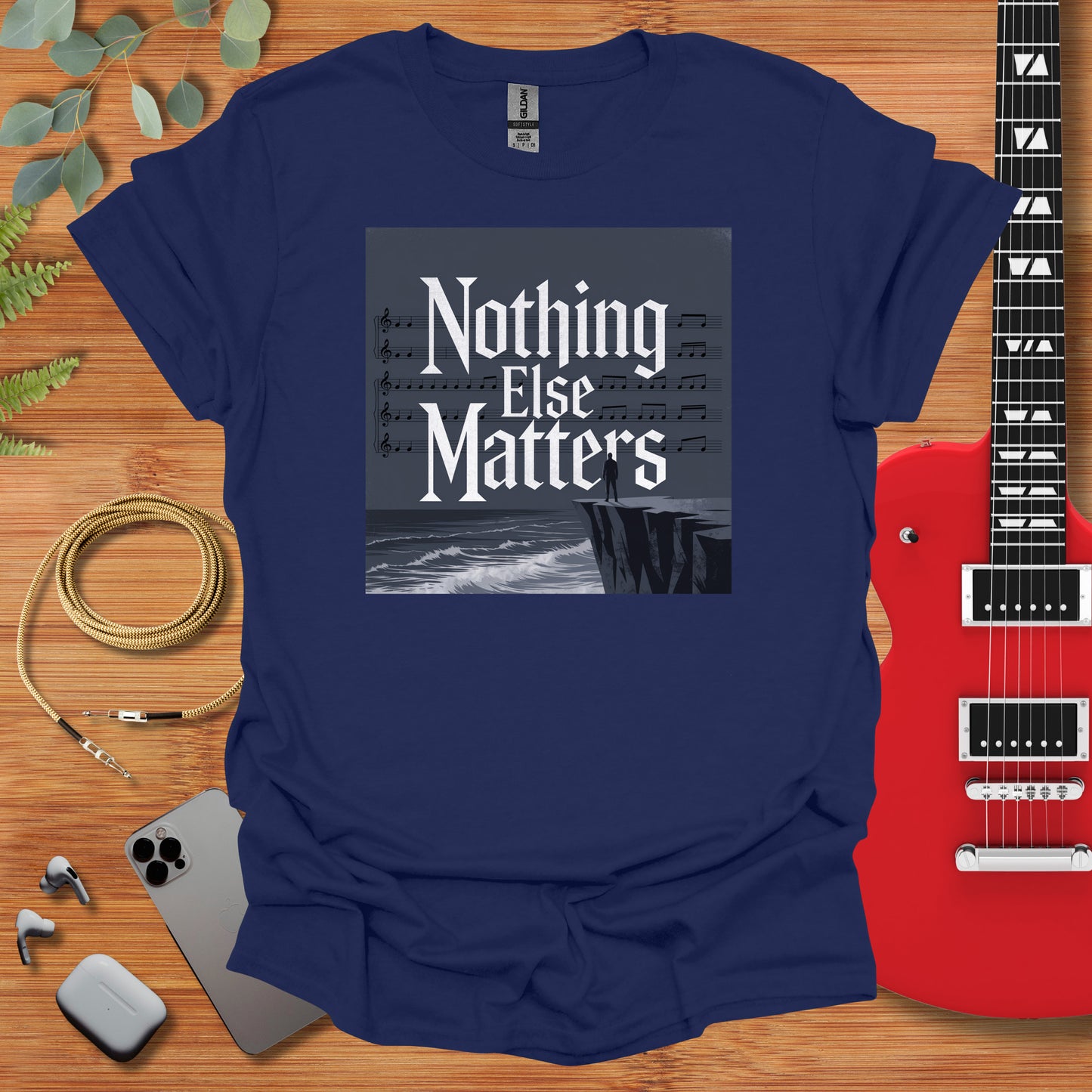 a t - shirt that says nothing else matters next to a guitar