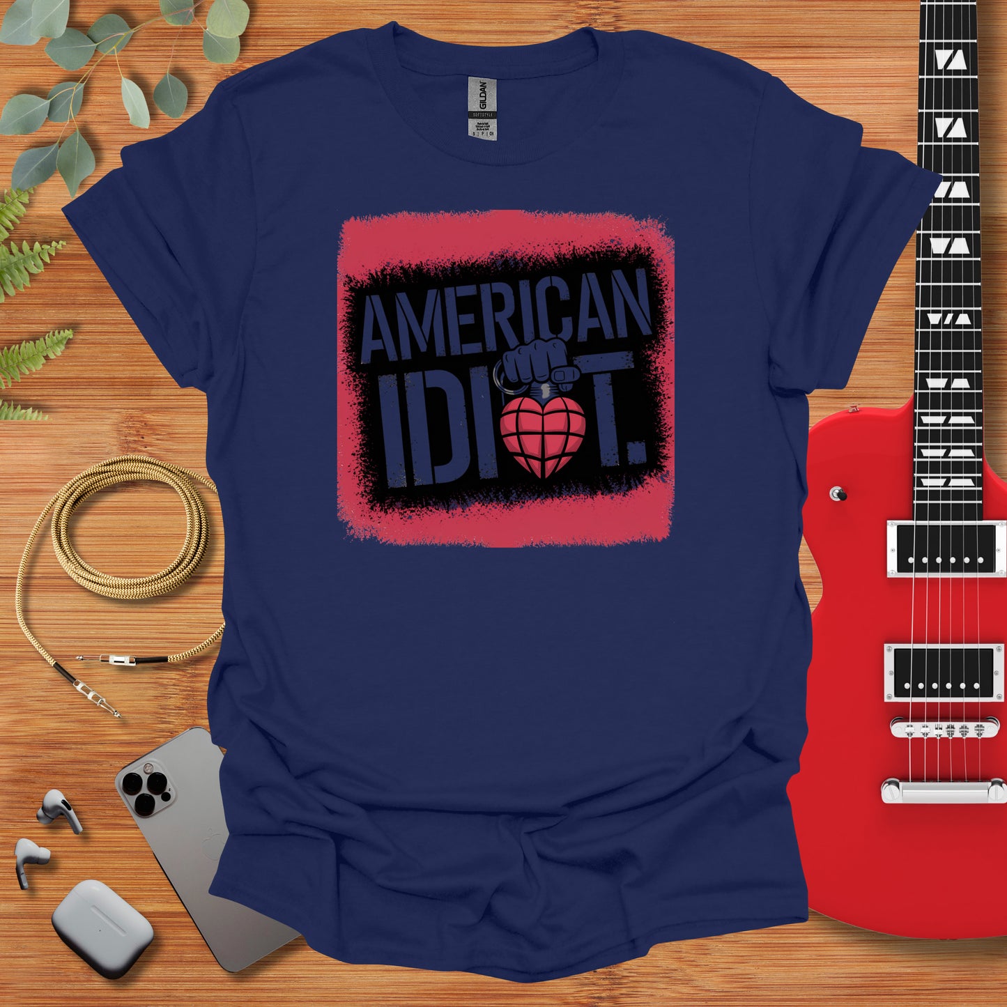 an american idiot t - shirt next to a guitar