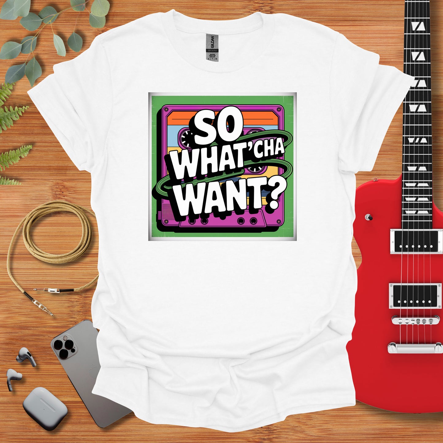 a t - shirt that says so whatcha want? next to a guitar