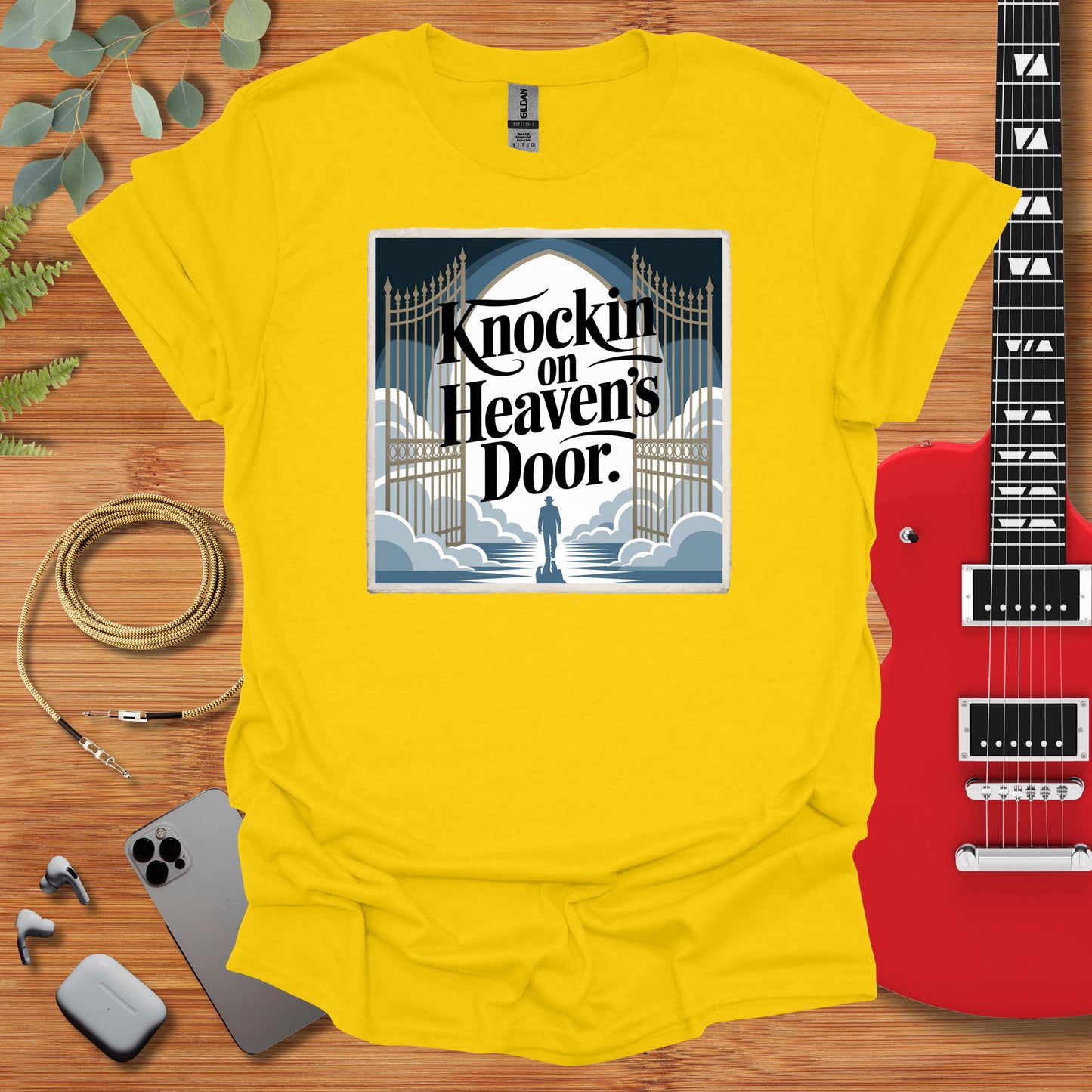 a yellow t - shirt with a guitar next to it