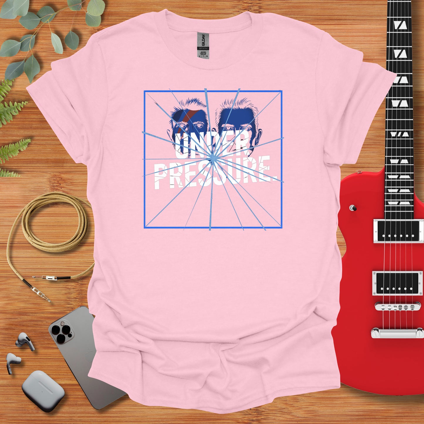 a pink t - shirt with a guitar next to it