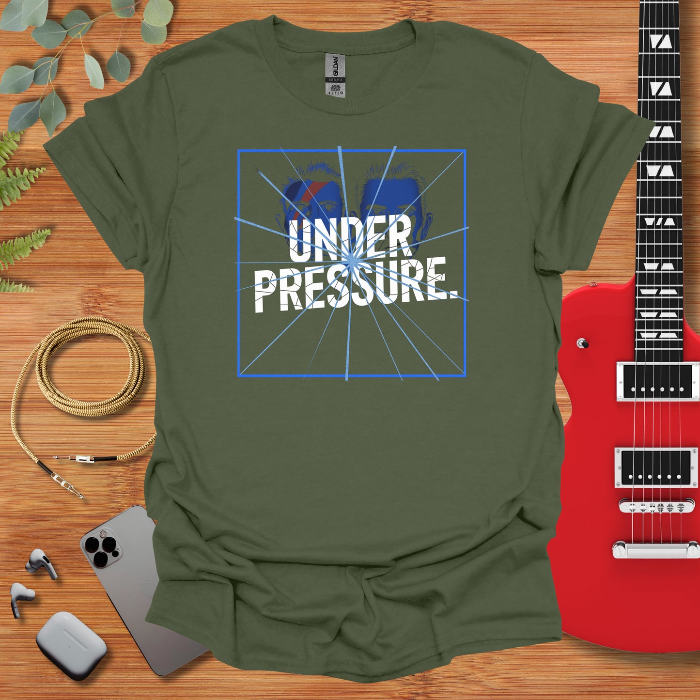 a t - shirt that says under pressure with a guitar next to it