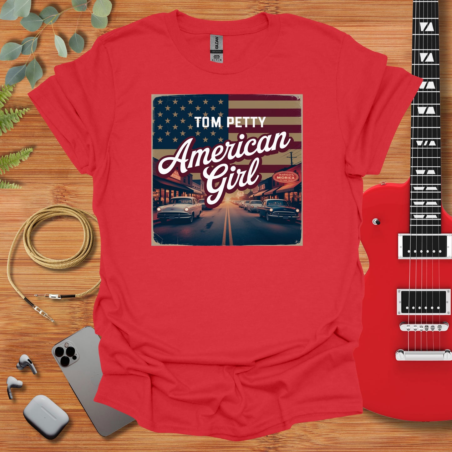 a red shirt with the american girl on it next to a guitar