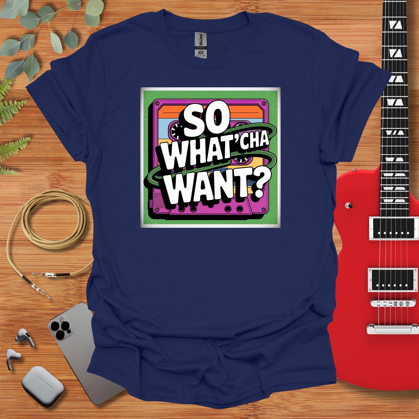 a t - shirt that says so whatcha want? next to a guitar