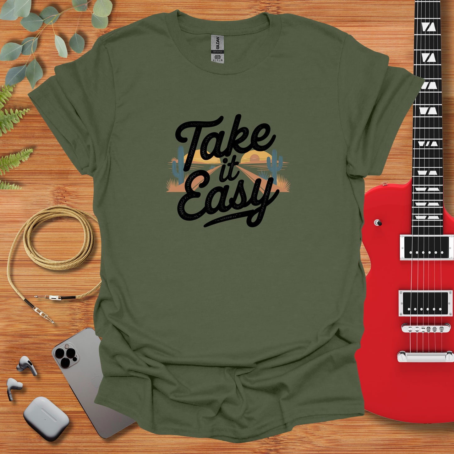 a t - shirt that says take it easy next to a guitar