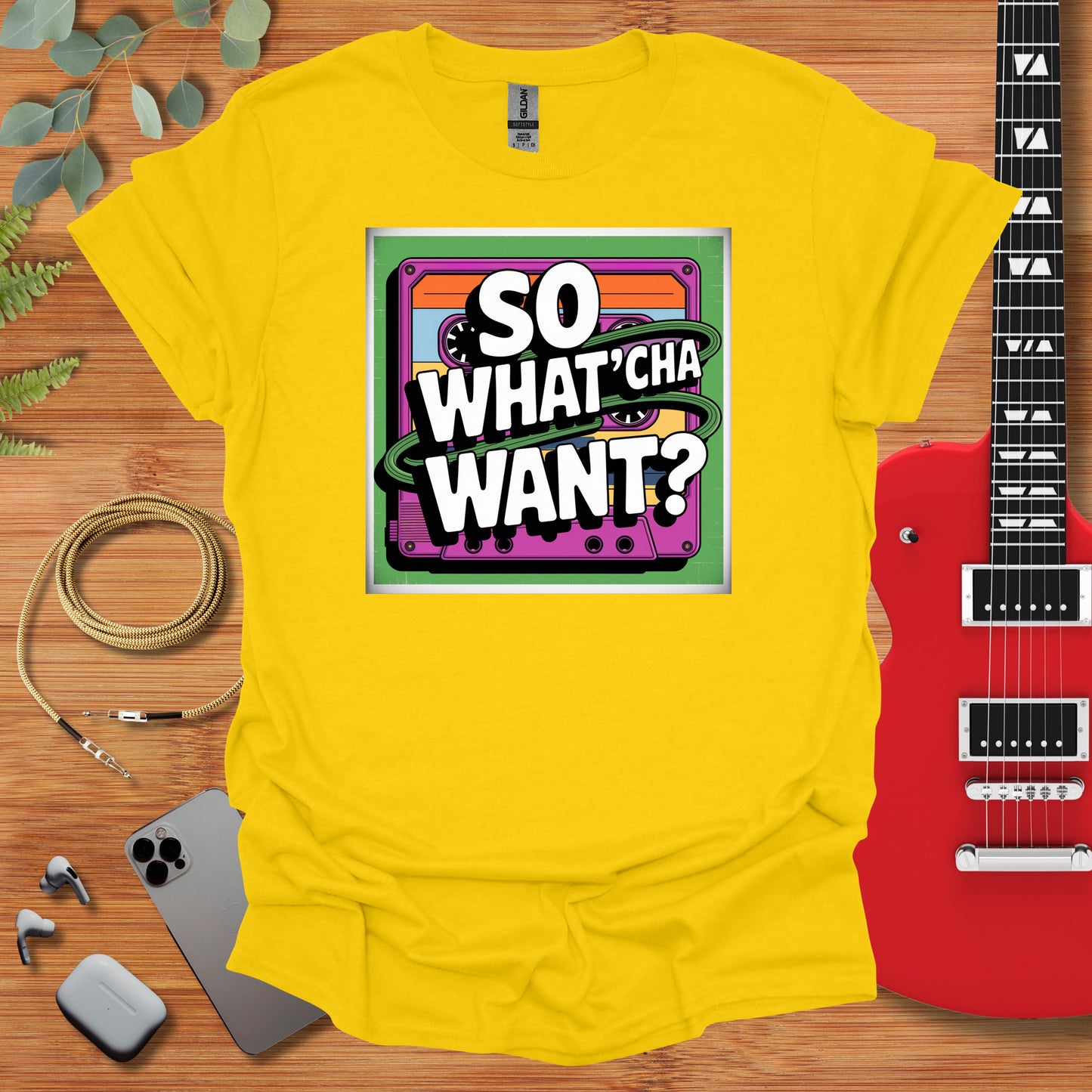 a t - shirt that says so whatcha want? next to a guitar