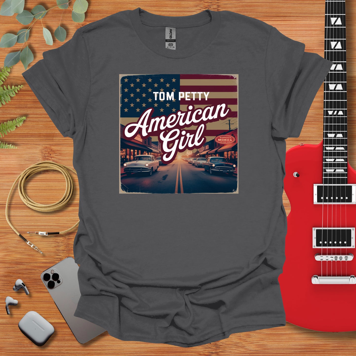 an american girl t - shirt with a guitar next to it