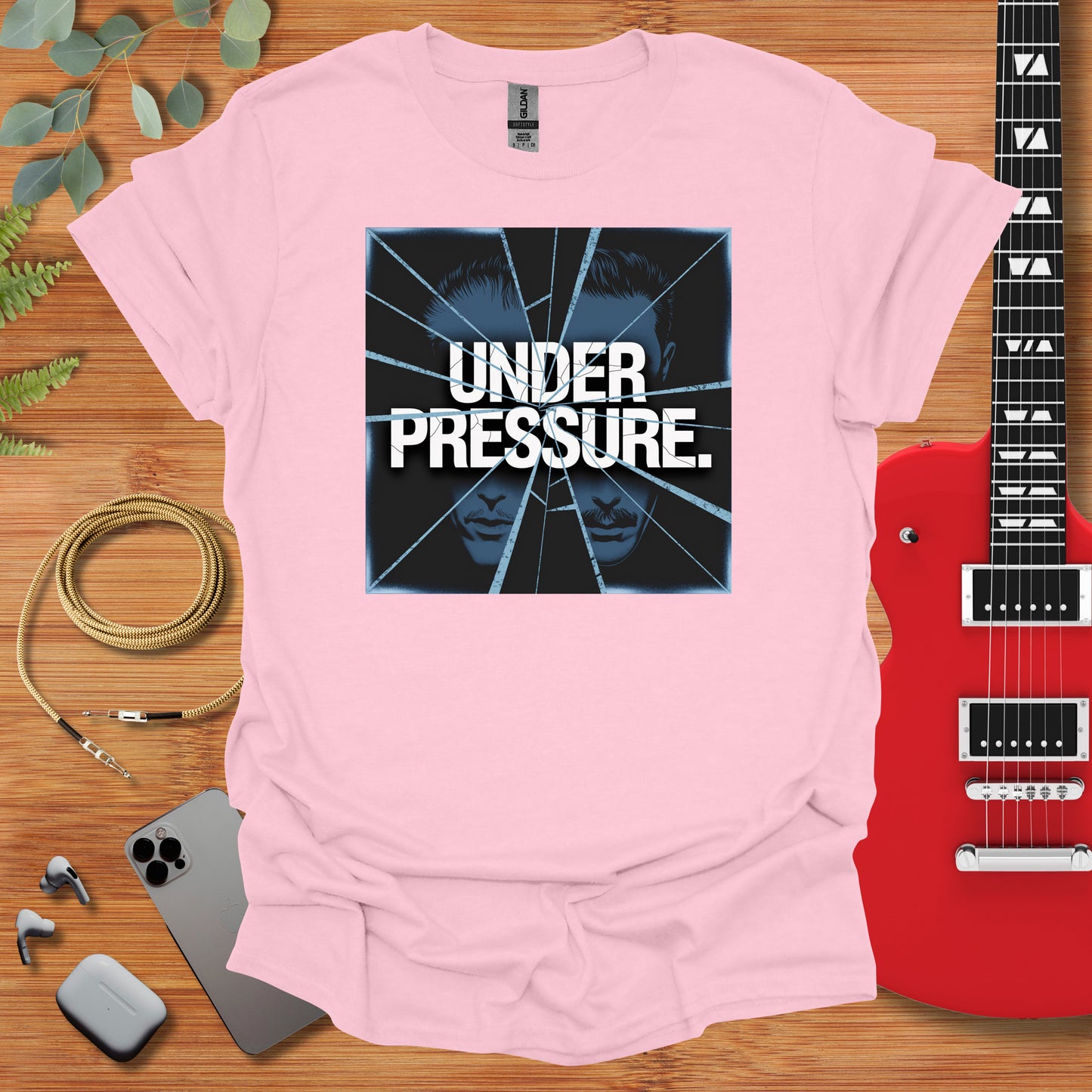 a pink t - shirt with a guitar next to it