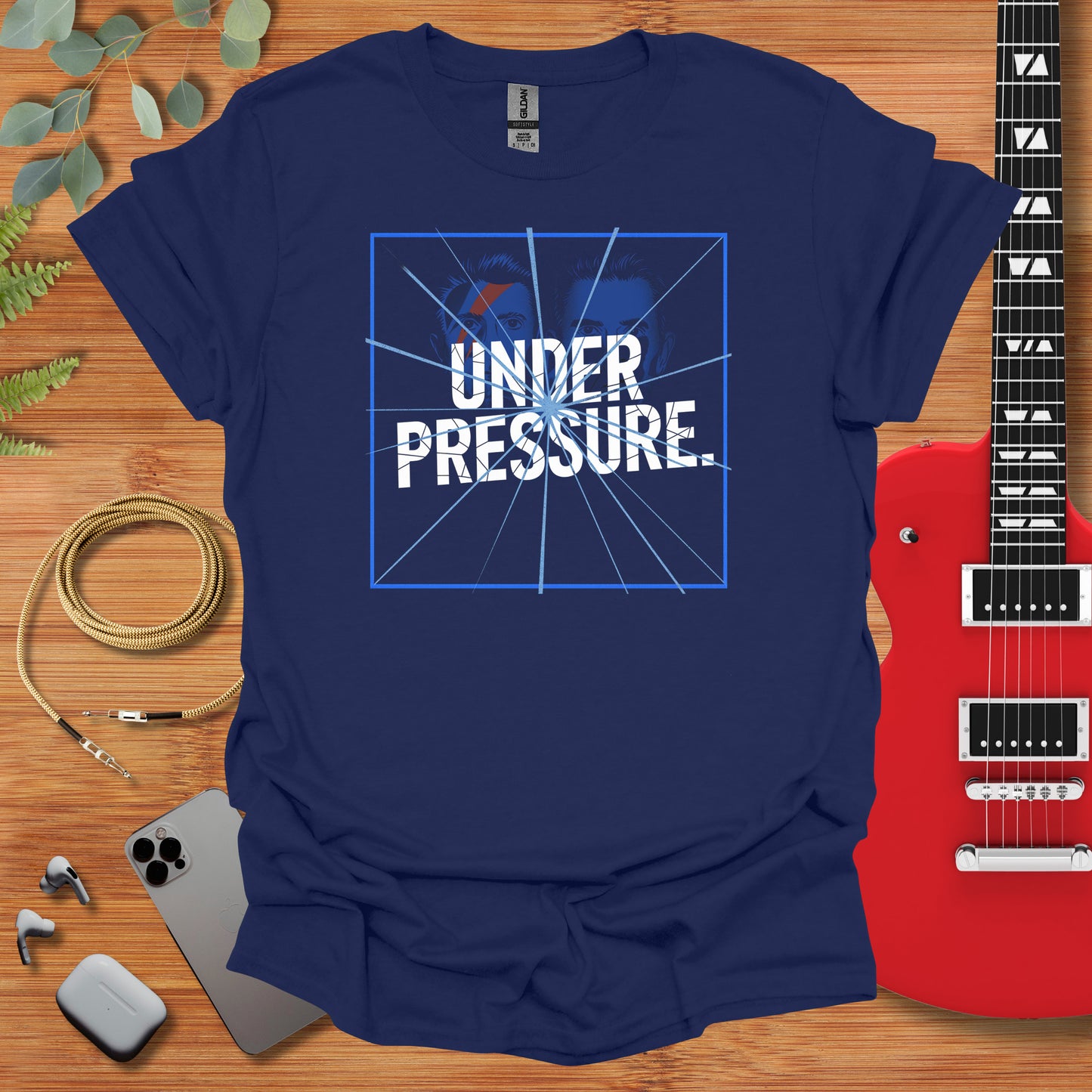 a t - shirt that says under pressure with a guitar next to it