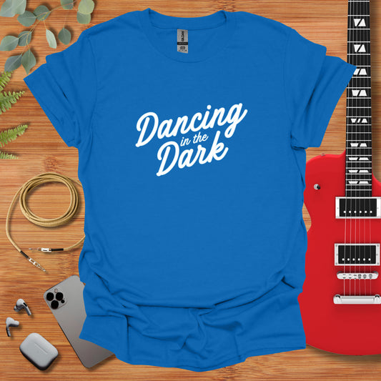 a t - shirt that says dancing in the dark next to a guitar