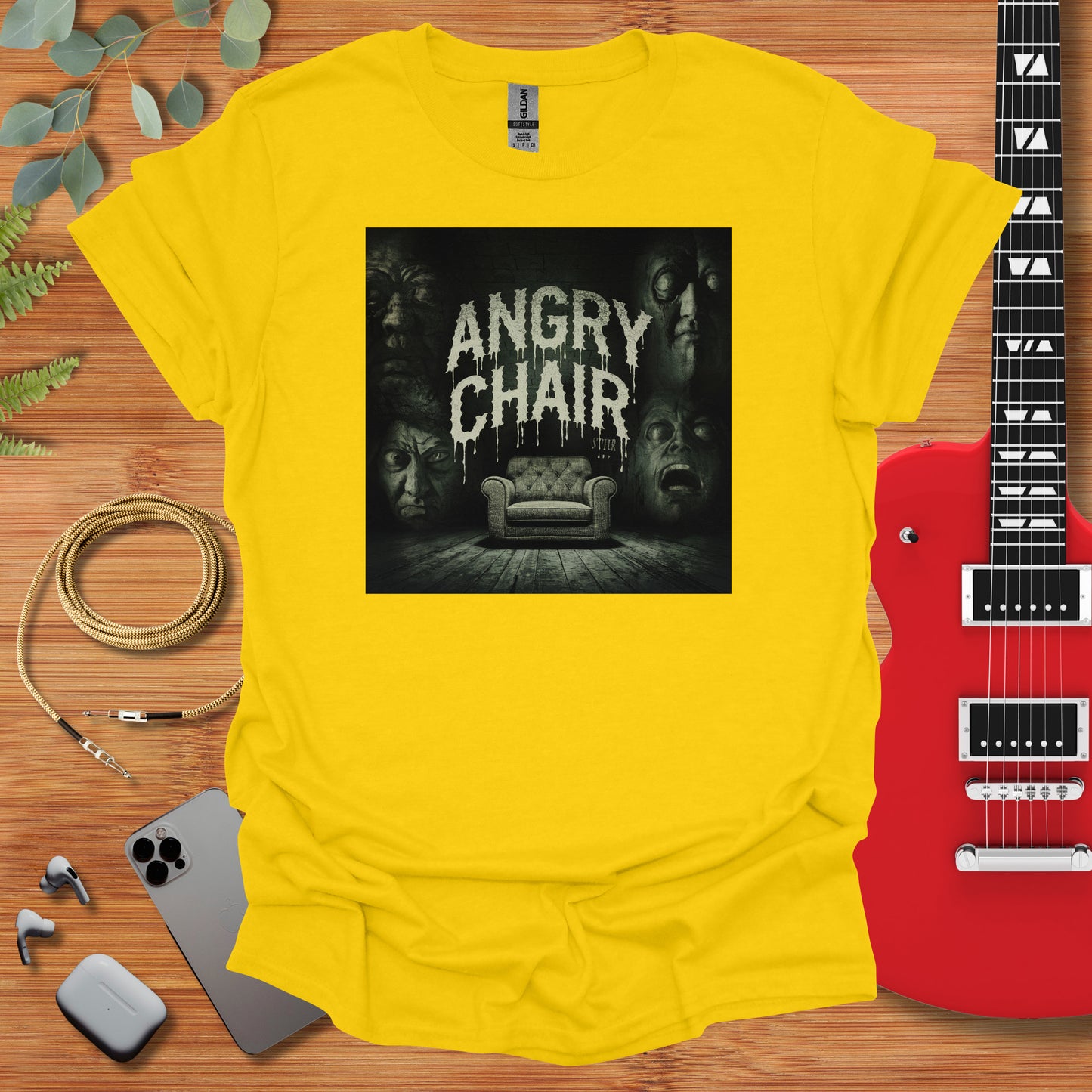 a yellow t - shirt with an image of a couch and a guitar