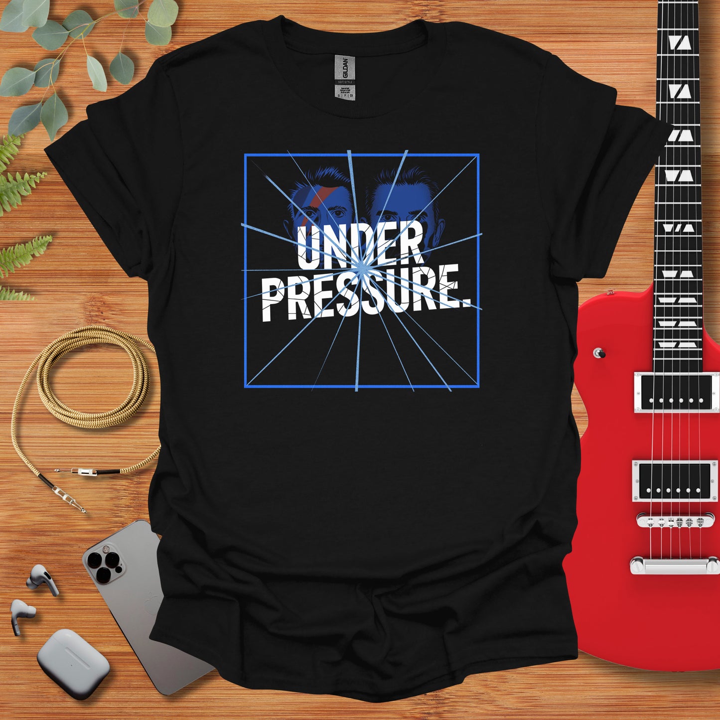 a t - shirt that says under pressure with a guitar next to it