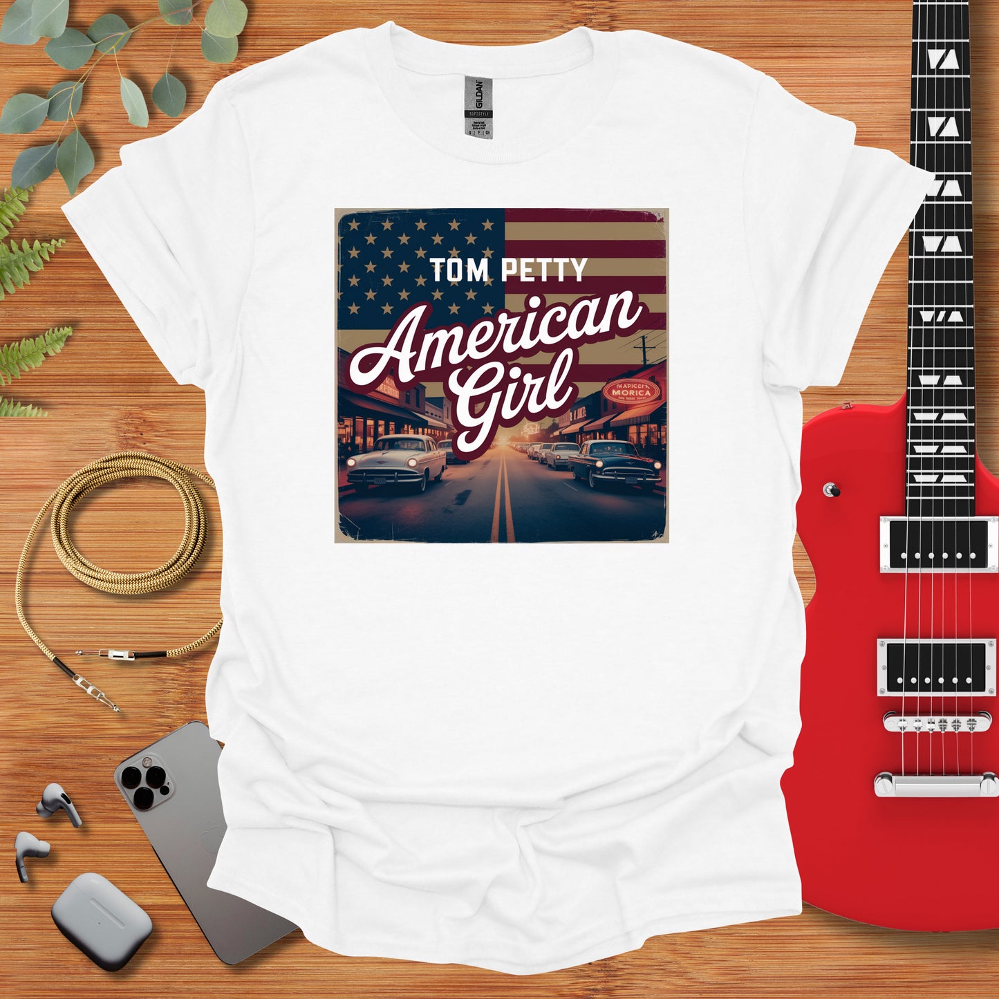 a t - shirt with the american girl on it next to a guitar