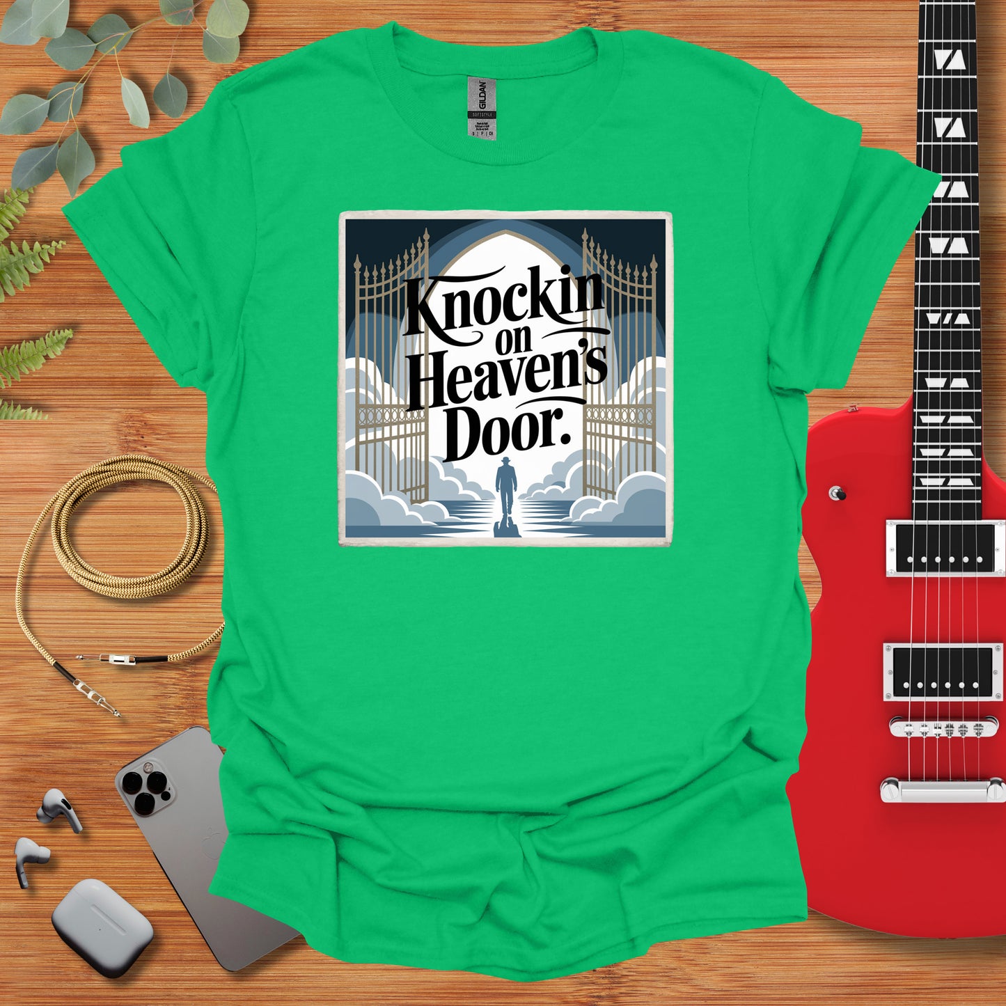 a green t - shirt with a guitar next to it