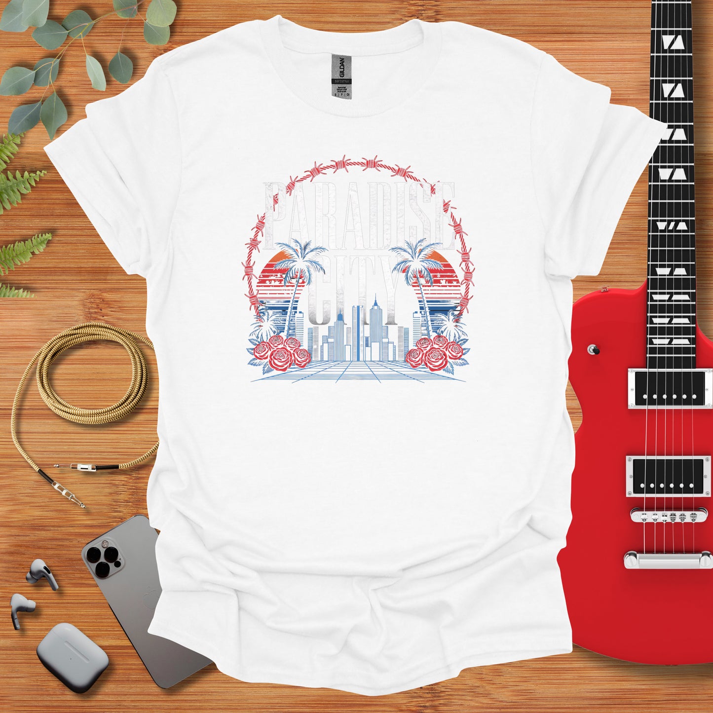 a white t - shirt with a picture of a city and a guitar